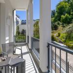 Terrasse mit Sitzgruppe und Blick auf grünen Hang.
