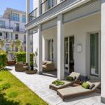 Terrasse mit Liegen, Sitzgruppe und Grünflächen. Hintergrund: modernes Wohnhaus.