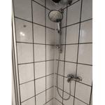 Dusche mit Chromarmatur und Duschbrause an Wand