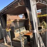 Terrasse mit Pavillon, Sitzgruppe und Tisch unter Schutz vor Sonne und Wind.