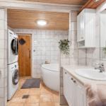 Bathroom with bathtub, washing machine, and mirror