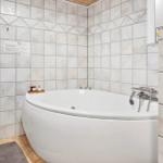 Shower with bathtub, tiled wall, and plant