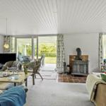 Living room with fireplace, sofa, table, and view of the garden.