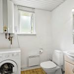 Bathroom with washing machine, toilet, and sink.