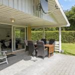 Terrace with seating group, garden table, and barbecue area. Glass doors lead into the living area.
