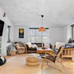 Living room with sofa, chair, and TV mounted on the wall.