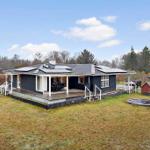 A dark-painted house with a terrace and an outdoor pool.