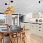 Kitchen with dining area, white cabinets, and wooden chairs around round table