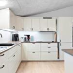Modern kitchen with white cabinets, stainless steel appliances, and wood surfaces.