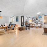 Living room with fireplace, sofa, chairs, and wall decor.