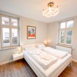 Gemütliches Schlafzimmer mit viel Tageslicht und modernem Design.