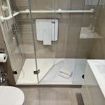 Dusche mit Rollstuhlgängigkeit, WC und Waschbecken.