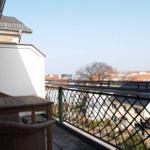 Terrasse mit Tisch und Stühlen, Blick auf Wohngebiet und Gebäude