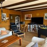 Living room with sofa, chair, table, TV, and foosball table.