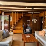 Living room with two sofas, table, and wooden stairs to upper level.
