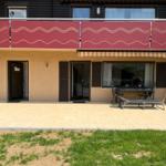Villa with terrace, grill area, and balcony with red railings.