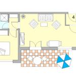 Ein Wohn- und Schlafzimmer mit Küche, Bad und Terrasse mit Tisch und Sonnenschirm.