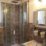 Bathroom with shower, sink, and window. Tiles with pattern.
