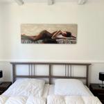 Bedroom with bed, nightstands, and wall art.