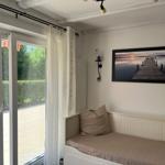 Room with bench, wall picture, and glass door to balcony.