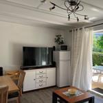 Living and dining area with TV, fridge, and view of the terrace.