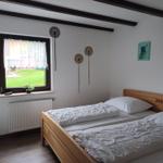 Bedroom with double bed, window to garden, and wall decor.