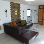 A living room with brown sofa, glass table, and wooden cabinet.