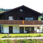 House with balcony, terrace and garden. Background: forest.