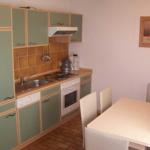 Kitchen with dining area, green cabinets, and brown tiles