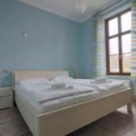 Schlafzimmer mit Doppelbett, Fenster und Nachttisch.