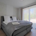 Schlafzimmer mit großem Bett, Fenster und Holzboden.
