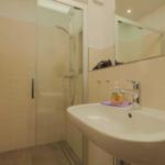 Bad mit Dusche, Waschbecken und Spiegel