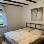 Bedroom with bed, window, and wall art.