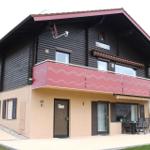 Two-story holiday home with balcony, terrace, and entrance door. House number 68.