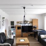 Living room with sofa, table, TV, and foosball table.