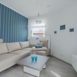 Wohnzimmer mit Sofa, Couchtisch und Fernseher. Wand mit Streifenmuster.