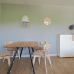 Essbereich mit Holztisch, vier Stühlen und Sideboard an der Wand.