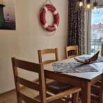 Esszimmer mit Holztisch, Stühlen und Fensterblick auf Balkon