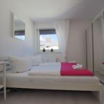 Schlafzimmer mit Doppelbett und großem Kleiderschrank
