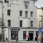 Fassade eines mehrstöckigen Gebäudes mit Geschäft und Eingang
