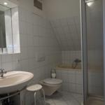 Badezimmer mit Dusche, Badewanne, Toilette und Waschbecken.