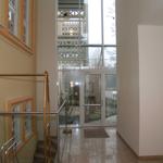 Haus mit Eingangsbereich, Glaswand und Treppe mit Metallgeländer.
