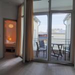 Wohnraum mit Balkon, Tisch und Stühlen. Durchgang zur Schlafzimmer.