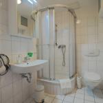Badezimmer mit Dusche, Waschbecken und Toilette. Trockner an der Wand.