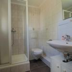 Badezimmer mit Dusche, WC und Waschbecken mit Spiegel