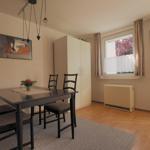 Esszimmer mit Tisch, Stühlen, Kleiderschrank und Fenster mit Blick.
