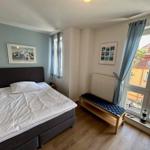 Schlafzimmer mit Doppelbett, Fenster und Holzboden