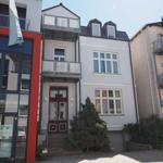 Haus mit Eingangstür, Balkonen und Fenstern an der Straße
