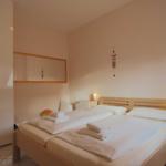Schlafzimmer mit Bett, Kleiderschrank und Spiegel an der Wand.