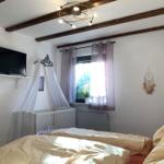 Bedroom with crib, TV, and window with curtains.